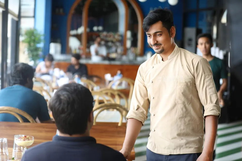A café host talking with a guest in Bengaluru