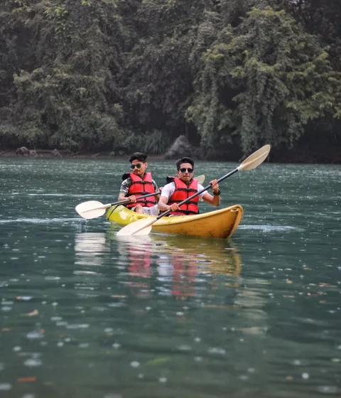 Two friends kayaking together on the Kali River in Dandeli, India